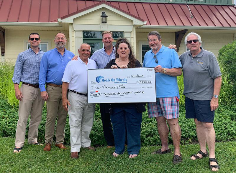 Every year, Cape Gazette teams up with RehobothFoodie.com and other generous sponsors to benefit Meals on Wheels Lewes-Rehoboth through Coastal Delaware Restaurant Week. Participants in this year’s check presentation are (l-r) Cape Gazette Co-Publisher and General Manager Chris Rausch; Clark Service Group President and CEO Glenn Clark Jr.; Meals on Wheels Lewes-Rehoboth board members Harry Papaleo and David Humes; Meals on Wheels Executive Director Kathy Keuski; Governing Board President John Wolfle; and board member Bob Yesbek of RehobothFoodie.com. SUBMITTED PHOTO